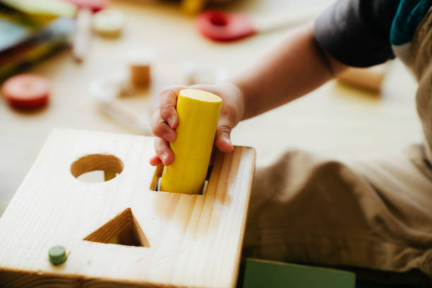 enfant jouant avec des formes en bois